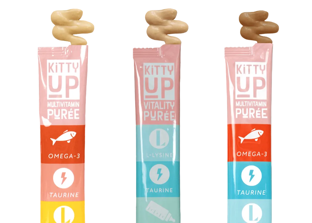Three Kitty Up purée treat tubes—Multivitamin and Vitality—with swirls of purée on top, shown on a gray background.
