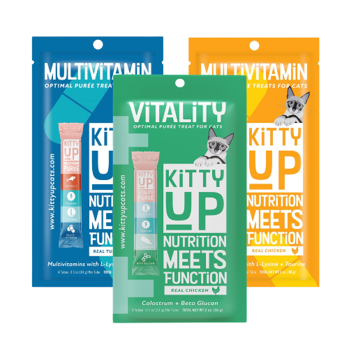 Three stand-up pouches of Vitality Kitty Up multivitamin treats for cats are shown against a white background, with blue, green, and orange packaging designs. The center green pouch is in front, with the other two partially visible behind it.